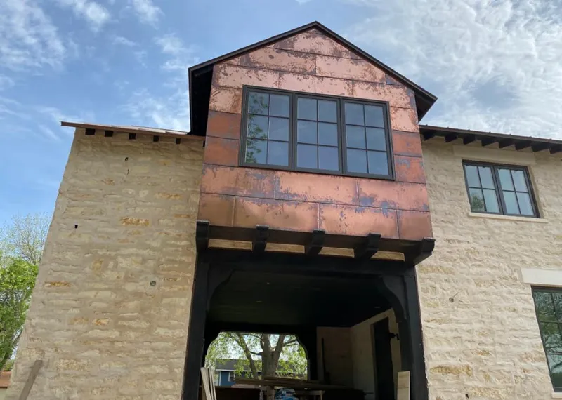 Copper metal panel facade on a stone building for Skylight Installation in Nixa