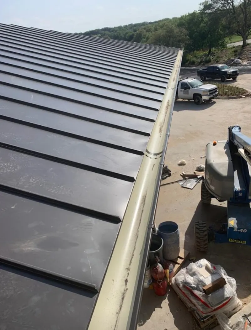 Standing seam panel and gutter detail on a metal roofing jobsite in Nixa